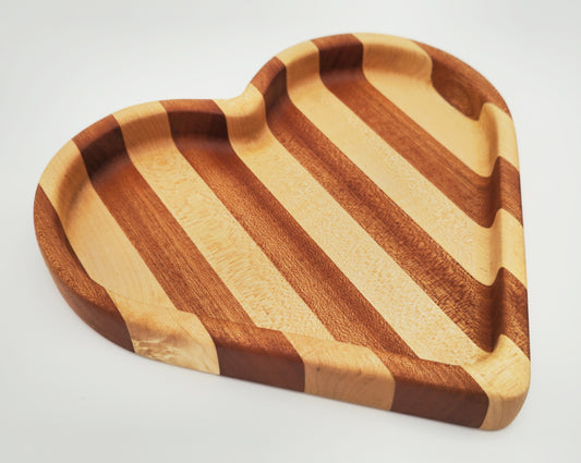 Wooden heart-shaped tray with striped pattern on a white background