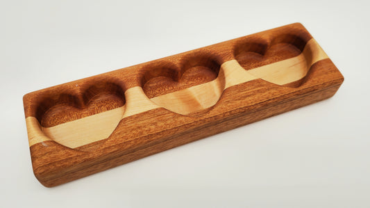 Wooden drink tasting tray with four compartments on a light gray background